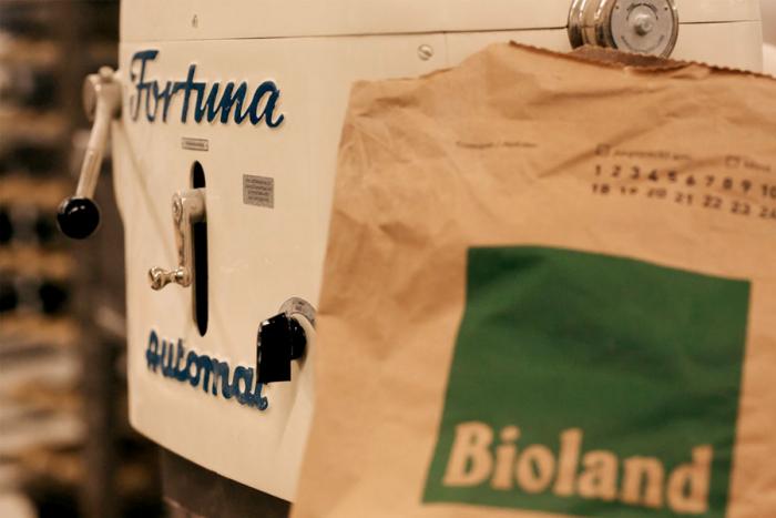 Eine Teigmaschine und ein Sack Mehl mit Bioland-Logo